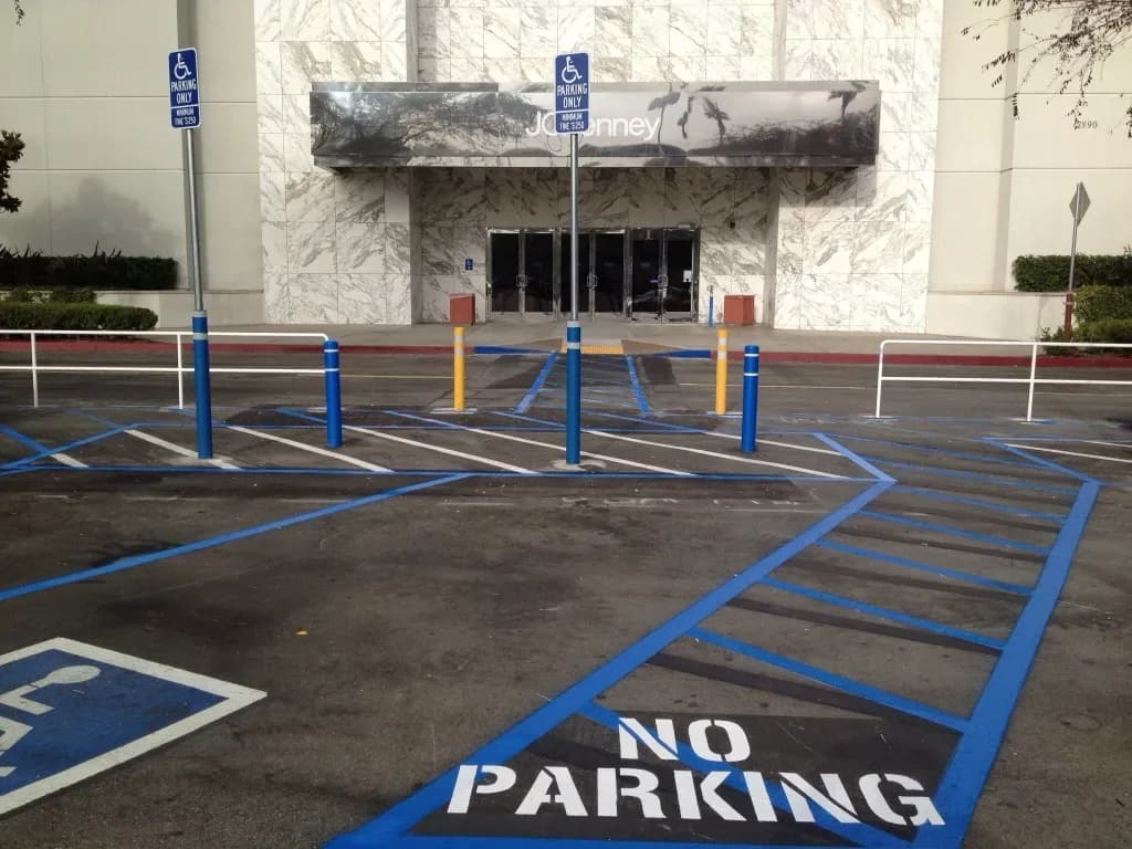 Accessible parking stalls, striped access aisles, posted signs, and the marked route to a commercial entrance