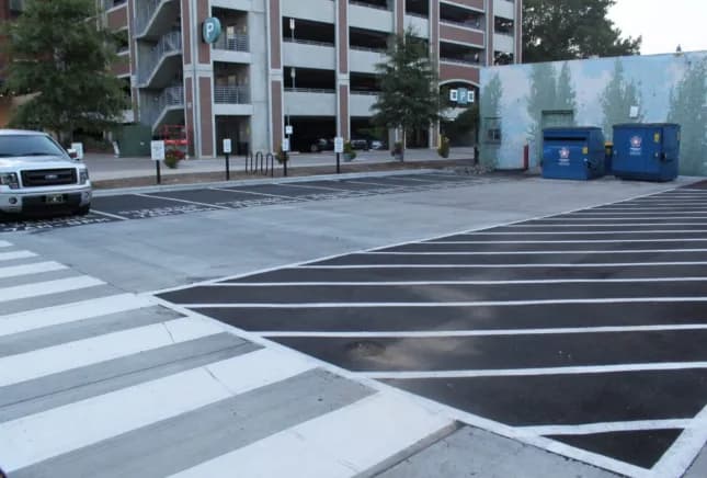 A commercial site using asphalt for the drive aisles and concrete for the crosswalk and entrance flatwork