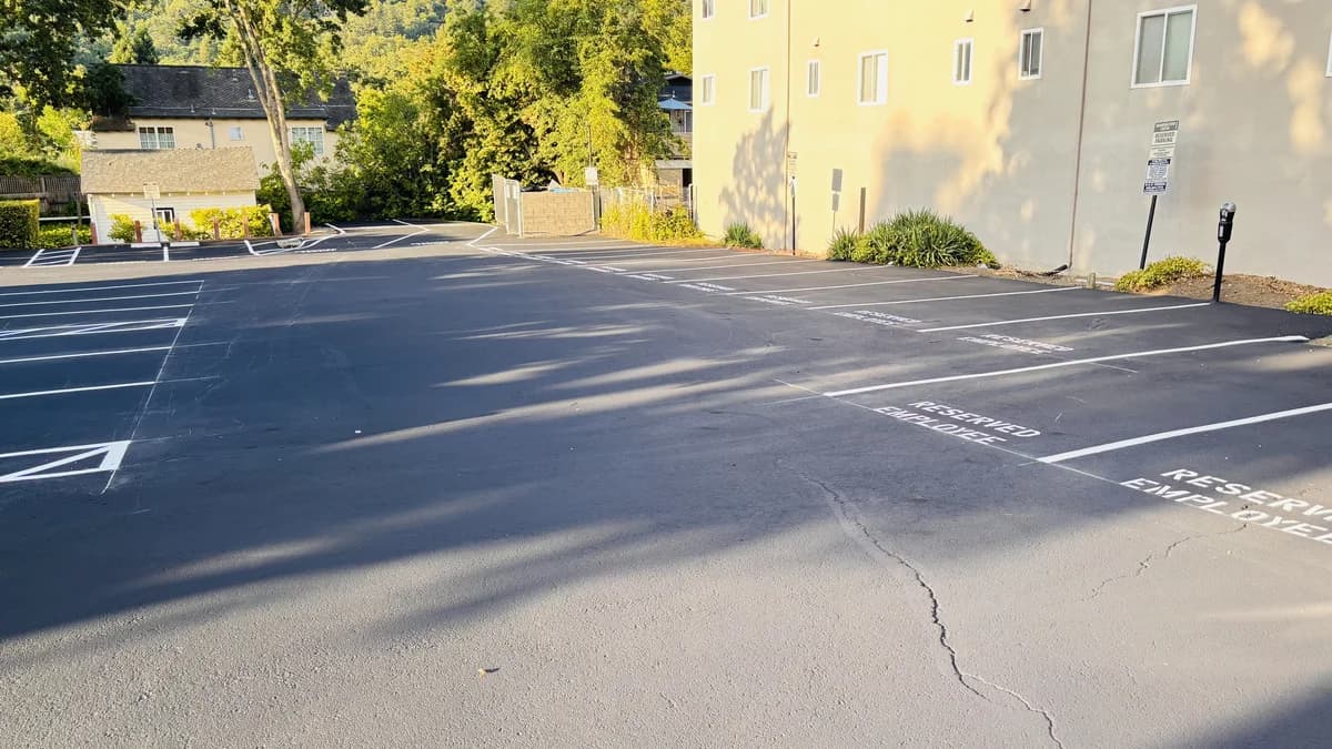 Freshly sealcoated apartment complex parking lot with restriped reserved employee stalls.