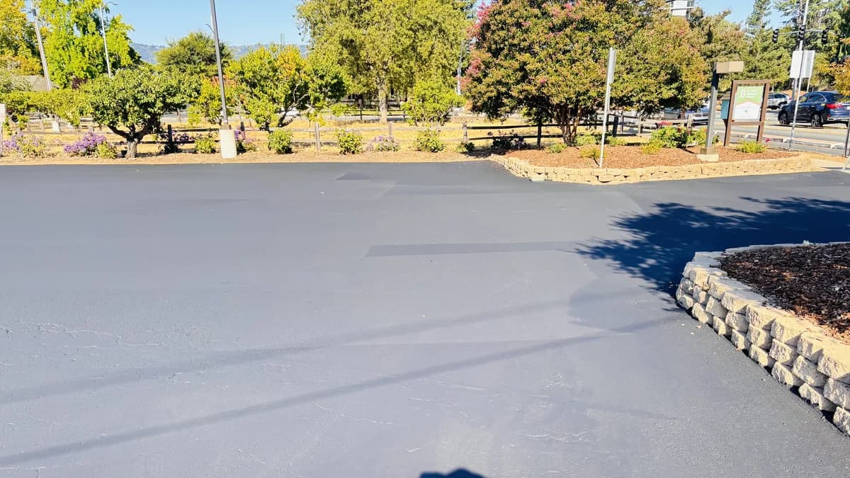 Sealcoated asphalt surface with a crack already visible reflecting through the new coating.