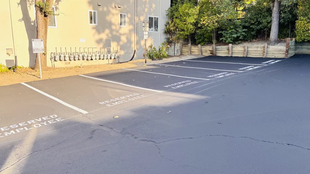 Deep black, evenly sealcoated apartment complex parking lot in sound condition.